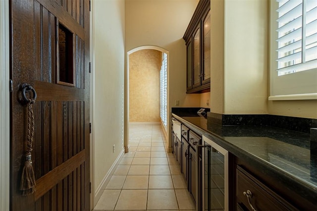 interior space with beverage cooler, tile patterned flooring, and baseboards