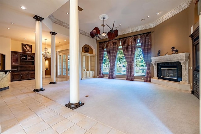 unfurnished living room featuring crown molding, light carpet, decorative columns, and a notable chandelier