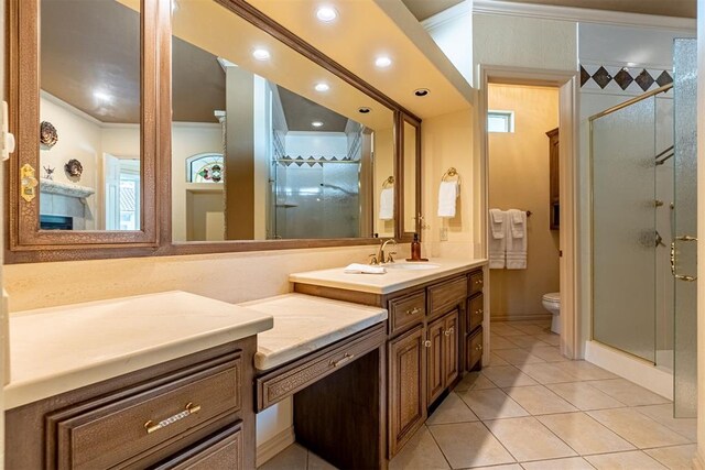 bathroom with tile patterned flooring, toilet, vanity, ornamental molding, and a shower stall