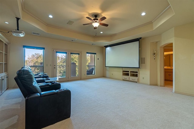 cinema with a ceiling fan, arched walkways, a raised ceiling, and crown molding