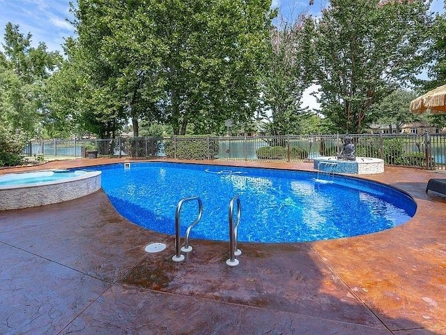 view of swimming pool featuring a pool with connected hot tub, fence, and a patio