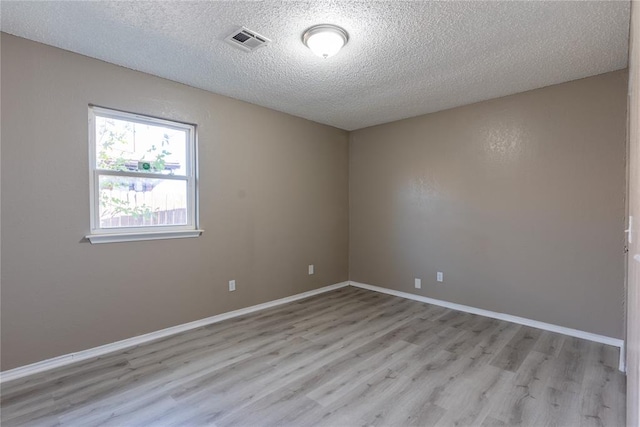 unfurnished room featuring a textured ceiling and light hardwood / wood-style floors