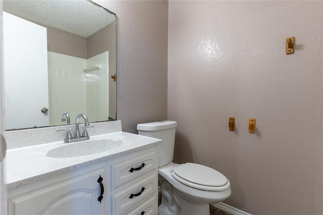 bathroom featuring vanity, toilet, and a textured ceiling