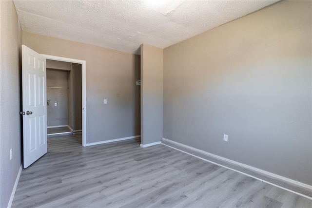 unfurnished bedroom featuring a textured ceiling and light wood-type flooring