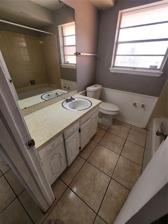 bathroom featuring tile patterned floors, plenty of natural light, vanity, and toilet