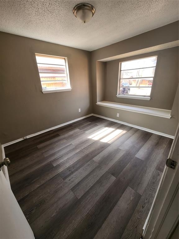 spare room with dark hardwood / wood-style flooring and a textured ceiling