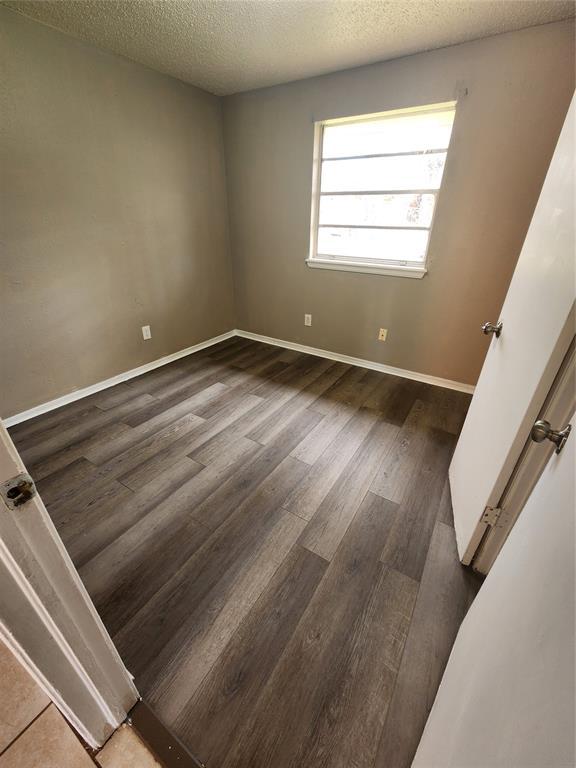 5300 Creekwood Ter, Oklahoma City, OK 73135 - spare room with wood finished floors and a textured ceiling