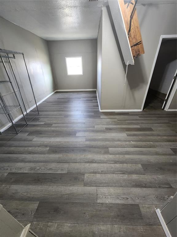 interior space with a textured ceiling and dark wood-type flooring