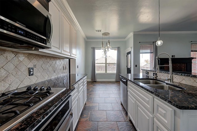 kitchen with hanging light fixtures, white cabinetry, sink, and stainless steel appliances