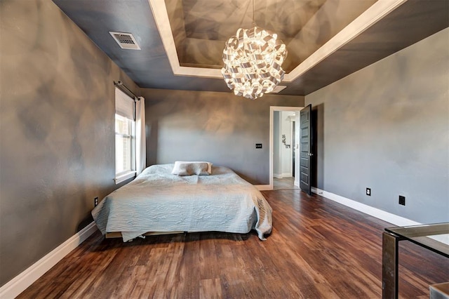 bedroom featuring a raised ceiling, dark hardwood / wood-style flooring, and an inviting chandelier