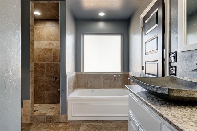 bathroom featuring shower with separate bathtub and sink