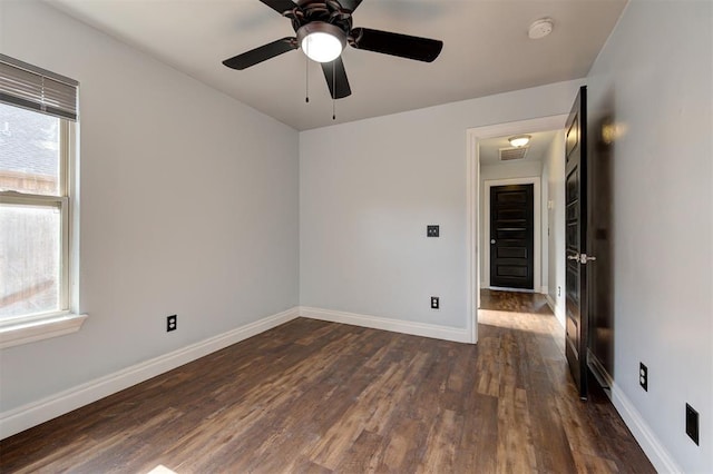 spare room with dark hardwood / wood-style flooring and ceiling fan