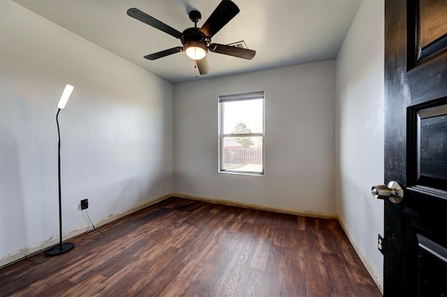 empty room with dark hardwood / wood-style flooring and ceiling fan