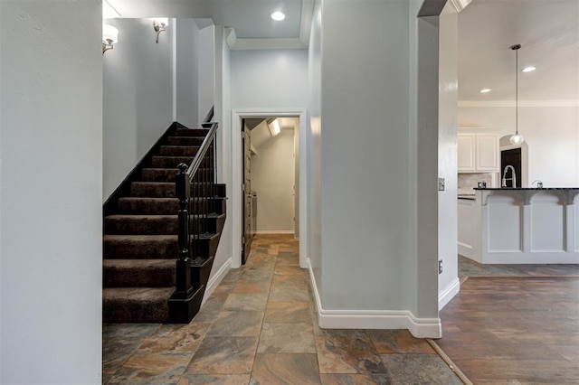 stairway featuring sink and crown molding