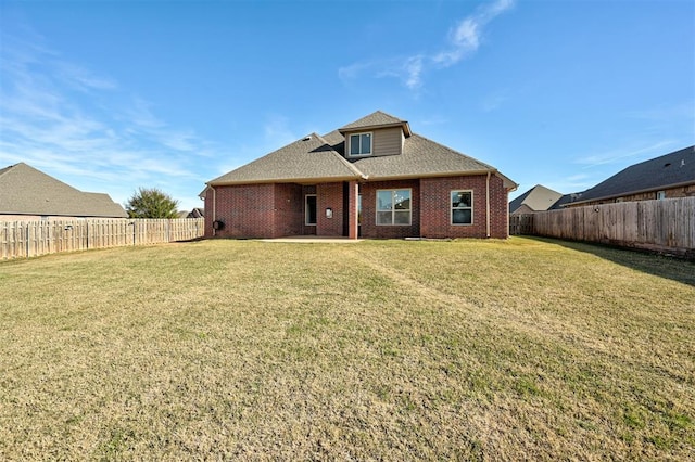 rear view of property featuring a lawn