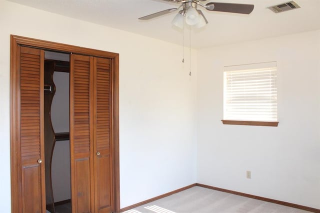 unfurnished bedroom with ceiling fan and a closet