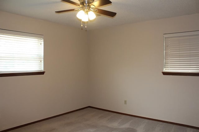 spare room featuring ceiling fan and light colored carpet