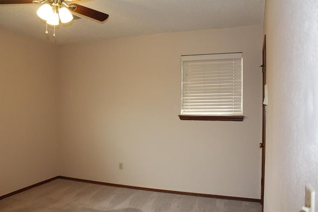 carpeted spare room featuring a textured ceiling and ceiling fan