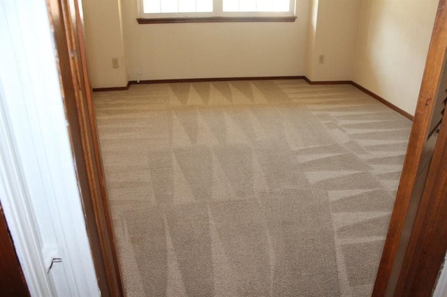 spare room featuring light carpet