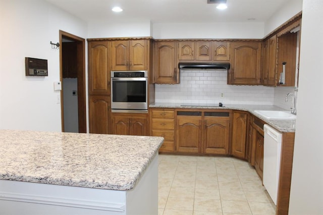 kitchen featuring black electric stovetop, oven, white dishwasher, sink, and tasteful backsplash