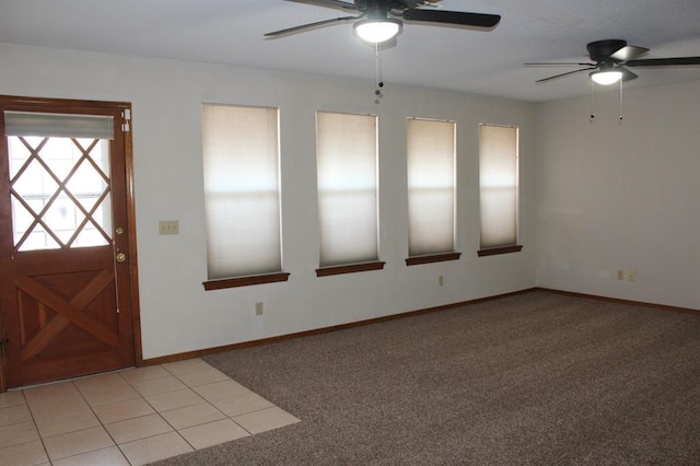 foyer entrance featuring ceiling fan and light carpet