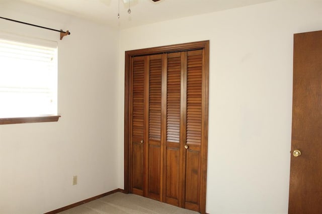 unfurnished bedroom featuring light carpet and a closet