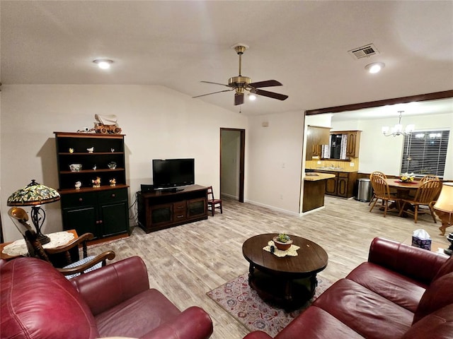 living room with ceiling fan with notable chandelier, light wood-type flooring, and vaulted ceiling