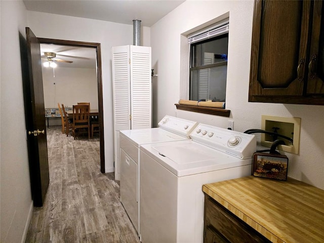 clothes washing area with ceiling fan, light hardwood / wood-style floors, cabinets, and independent washer and dryer