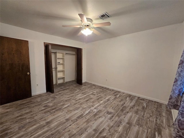 unfurnished bedroom featuring ceiling fan, a closet, and hardwood / wood-style flooring