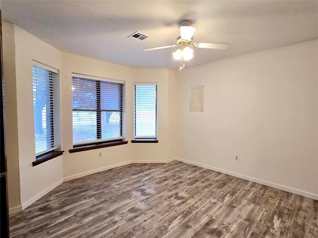 unfurnished room with ceiling fan, plenty of natural light, and wood-type flooring