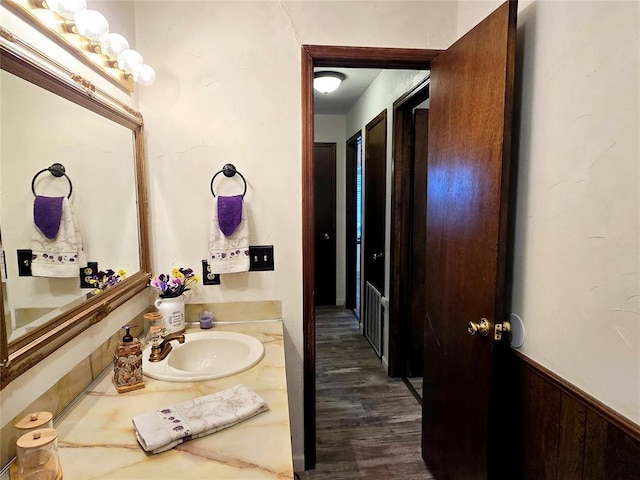 bathroom with vanity, wood-type flooring, and wooden walls