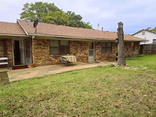 back of house featuring central air condition unit, a patio area, and a lawn