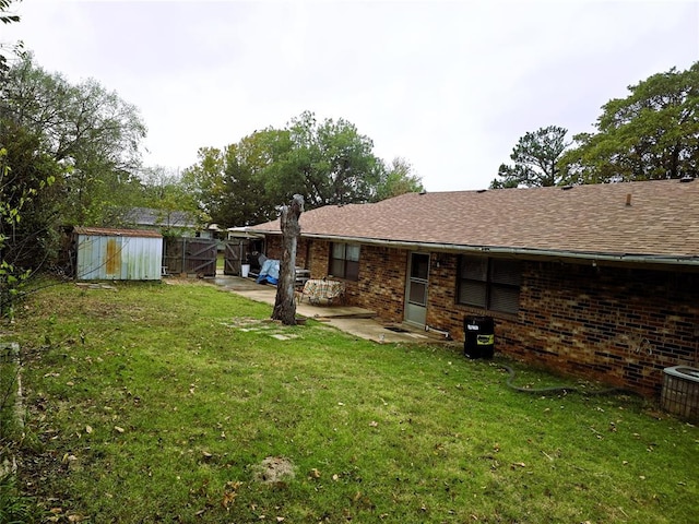 view of yard featuring a storage shed and a patio area