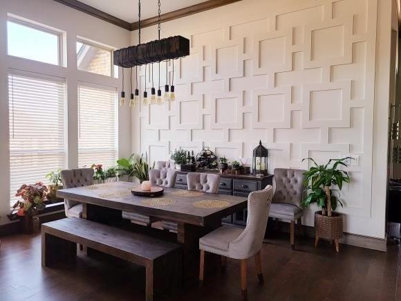 dining space featuring ornamental molding, dark wood-type flooring, and a chandelier