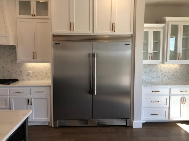 kitchen with white cabinets, dark hardwood / wood-style flooring, light stone counters, and appliances with stainless steel finishes