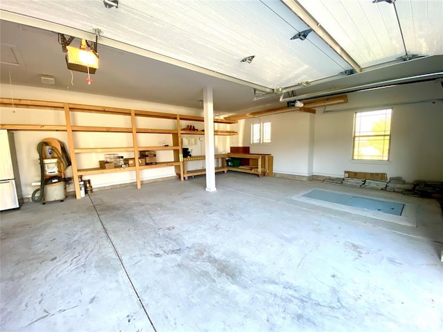 garage with stainless steel refrigerator and a garage door opener