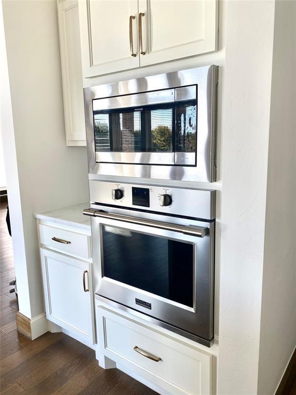 kitchen with white cabinetry, dark wood-type flooring, and stainless steel appliances