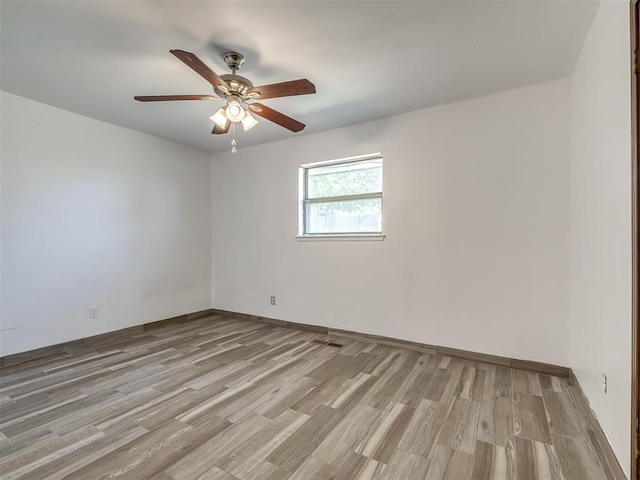 empty room featuring ceiling fan and light hardwood / wood-style flooring