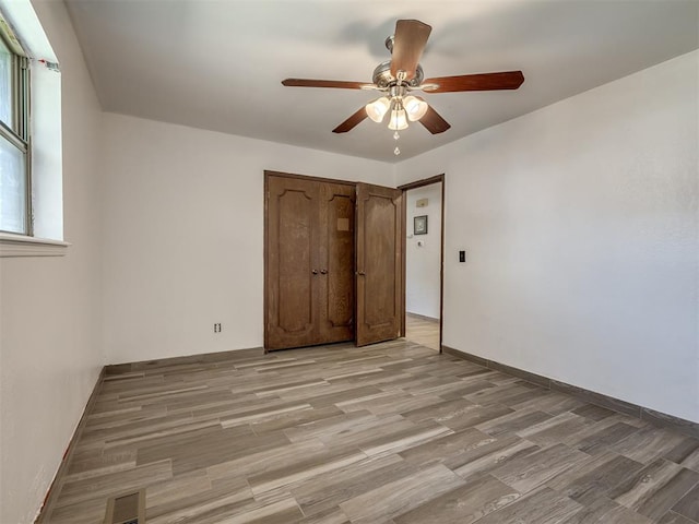 unfurnished bedroom with ceiling fan and light wood-type flooring