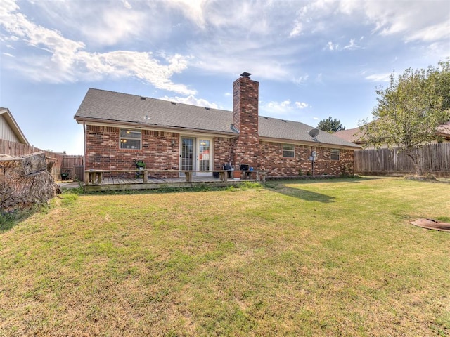 back of property with a lawn and a wooden deck