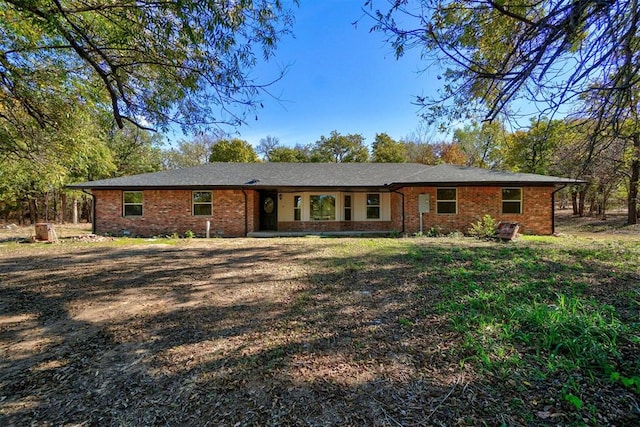 ranch-style home featuring a front yard and brick siding