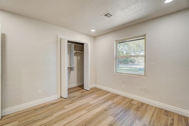 unfurnished bedroom with a closet and light hardwood / wood-style flooring