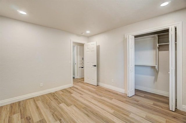 unfurnished bedroom featuring light wood-type flooring and a closet