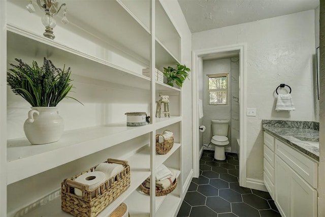 bathroom with tile patterned flooring, vanity, and toilet