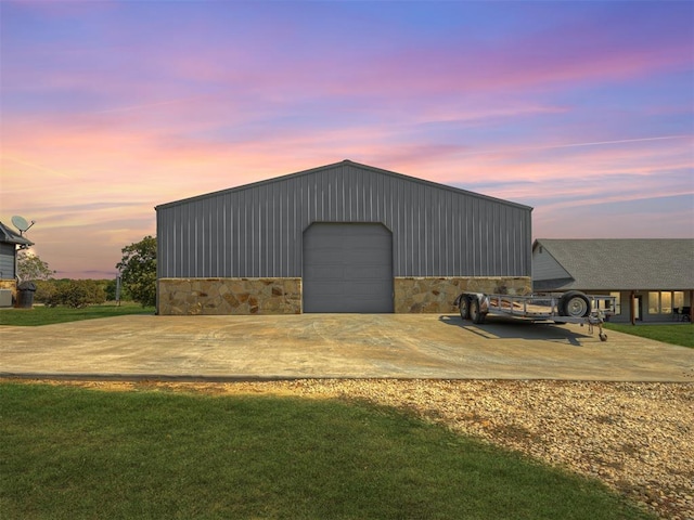 outdoor structure at dusk featuring a yard and a garage