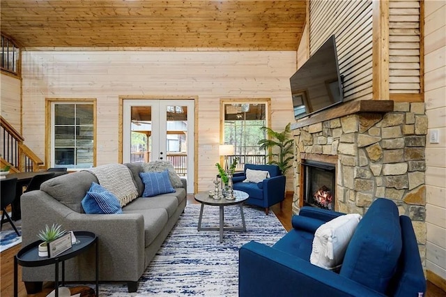 living room with french doors, wooden ceiling, hardwood / wood-style floors, wooden walls, and a fireplace