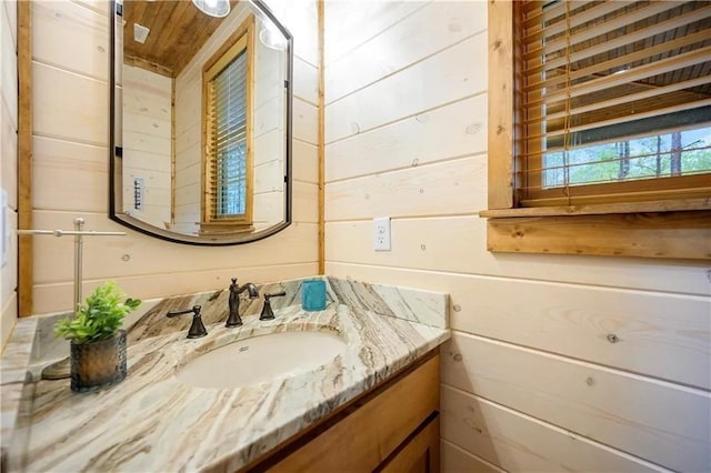 bathroom with wood walls and vanity