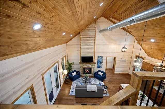 living room featuring wood walls, dark hardwood / wood-style flooring, wooden ceiling, and lofted ceiling