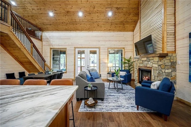 living room with french doors, high vaulted ceiling, wooden walls, and dark hardwood / wood-style flooring