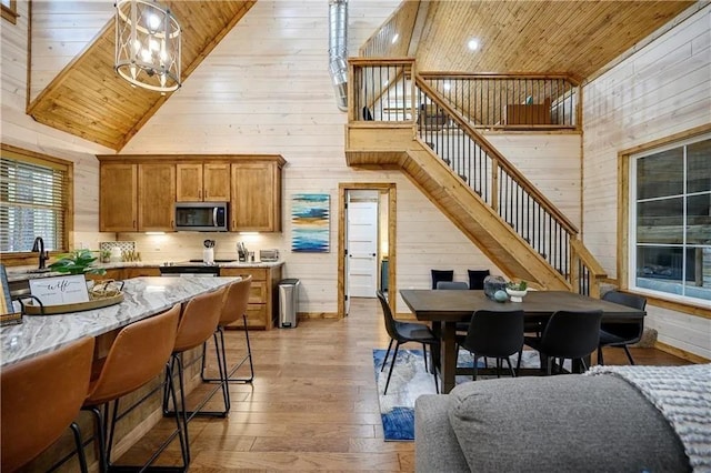 kitchen featuring light hardwood / wood-style floors, wooden walls, pendant lighting, and wood ceiling